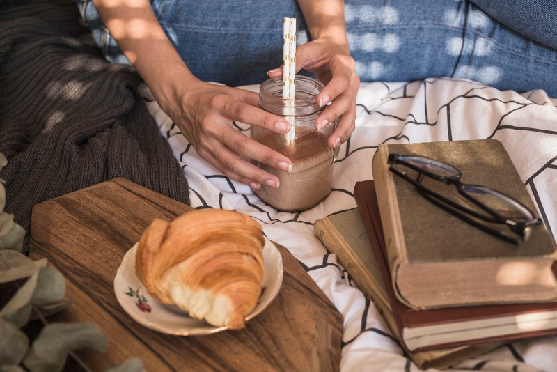 crop-woman-with-drink-near-books-croissant.jpg
